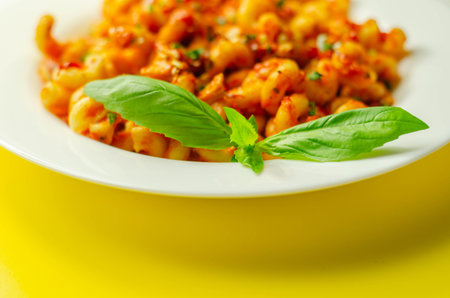 Cooked cellentani pasta with cooked chicken breast and peppers in a spicy tomato and jalapeno...