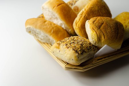 Various types of bread served on a wicker tray, delicious and fresh rolls, morning food