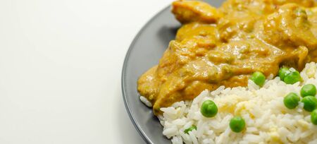 Chicken breast pieces in a mildly spiced coconut curry sauce with fried rice with peas and egg, Indian foodの写真素材