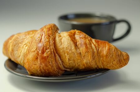 Delicious croissant on a plate with coffee in a cup, French breakfastの写真素材