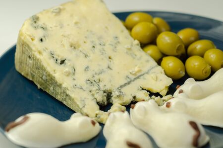 Full fat soft blue veined cheese with olives and snacks in the shape of mice, funny foodの写真素材