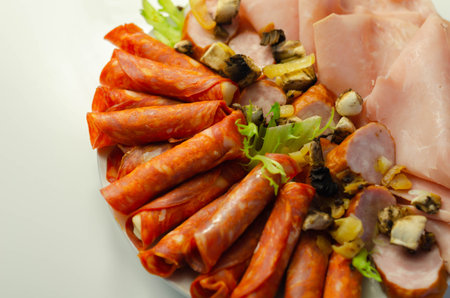 A cold plate prepared for the party with sliced chorizo, ham and sausages, a set of cold cuts