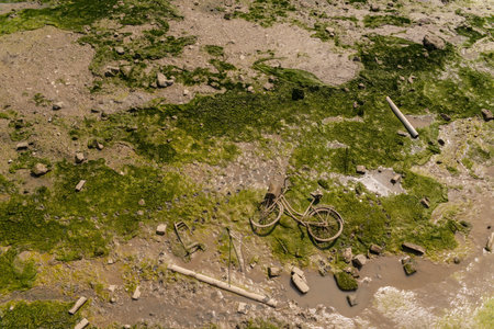 A discarded bicycle with a wicker basket to the canal, a typical example of environmental pollution...