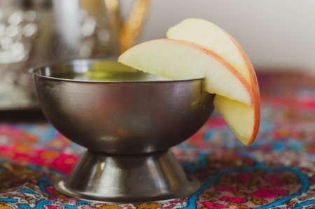 Metal goblet with a refreshing drink decorated with apple slices, celebrationの写真素材