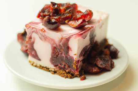 Japanese cheesecake with cherry sauce and fresh cherries on the ceramic plate and red background,...