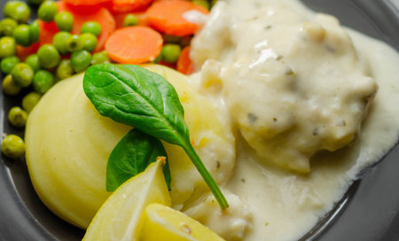 Cod Mornay, flaky cod with a creamy cheese sauce, with mashed potato, peas and carrots, British...