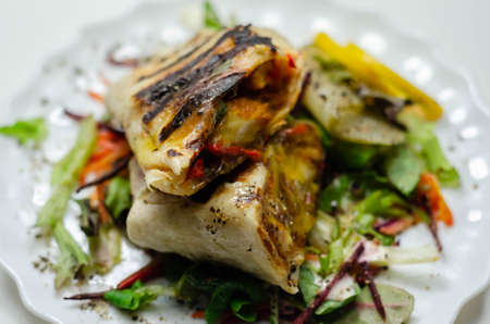 Grilled tortilla wrap with southern style chicken breast served on the mix salad, lunch timeの写真素材