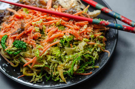 Cooked chicken breast pieces with egg noodles, carrots, and cabbage in a savory chow mein sauce, asian mealの写真素材
