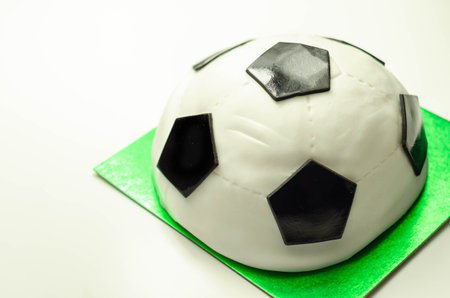 Football cake, sponge filled with frosting and raspberry jam, finished with soft icing and edible decorations, cake for a football playerの写真素材