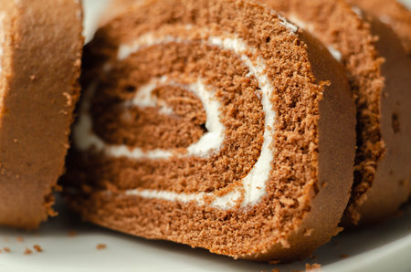 Chocolate sponge roll with a vanilla flavour filling, chocolate swiss roll, swirled cakeの写真素材