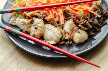 Cooked chicken breast pieces with egg noodles, carrots, and cabbage in a savory chow mein sauce, asian mealの写真素材