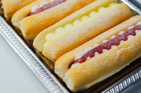 Mixed finger donuts filling chocolate, custard, jam and whipped cream, eclairs in different flavors,...