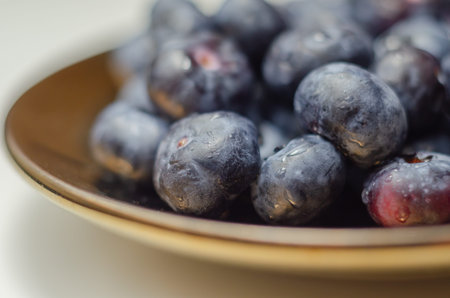Closeup on fresh and ripe blueberries on a white background, juicy fruits