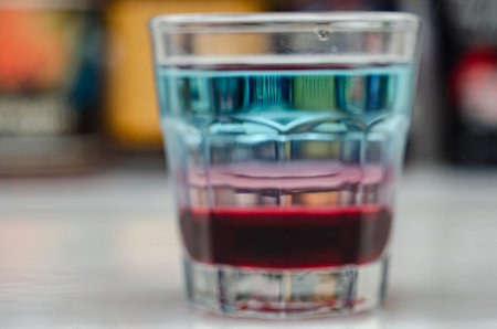 A colorful layered drink shot on a bar prepared by Bartender, party timeの写真素材