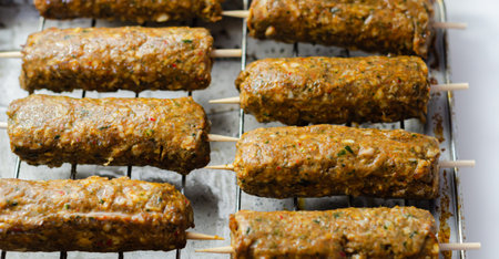 Minced and shaped lamb kebabs with chilli and coriander prepared for grill, traditional turkish...