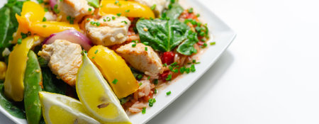 Cooked chicken breast pieces with peppers, sugar snap peas, and baby leaf spinach in a spicy sweet and sour sauce with fragrant rice, diet mealの写真素材