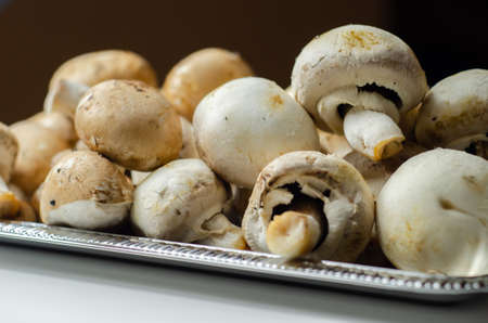 Portobello and white mushrooms on a silver plate, vegetables from an organic farm, natural foodの写真素材
