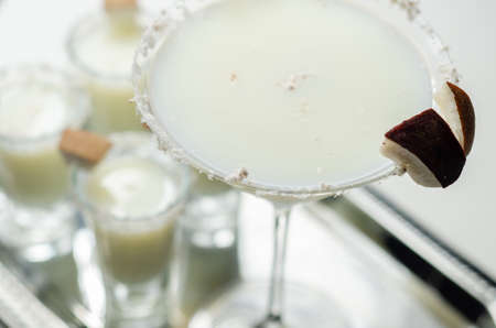 Coconut cocktail in martini glass based on the rum decorated with coconut flakes and coconut pieces, white drinkの写真素材