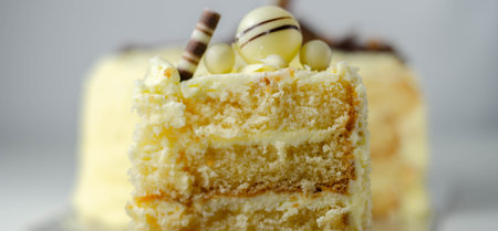 A piece of layered white cream cake with confectionery decorations, dessert for the celebration