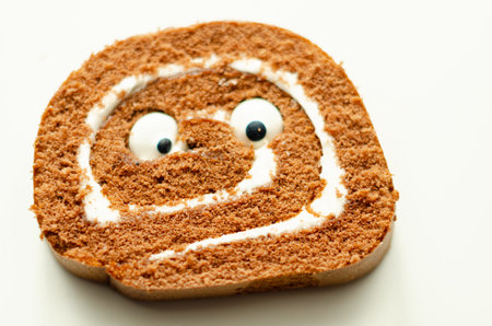 Chocolate sponge roll with a vanilla flavour filling with decorating sweet eyes, chocolate swiss roll, funny foodの写真素材