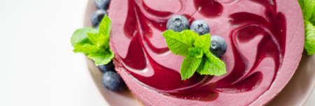 Baked vanilla and berries flavour cheesecake swirled with blueberry sauce on a digestive biscuit crumb, confectioneryの写真素材