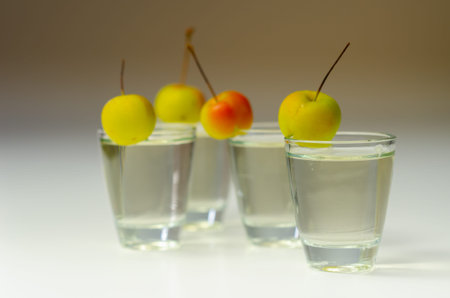 Delicious Calvados served in shot glasses decorated with crab apples, an alcoholic drink made of...