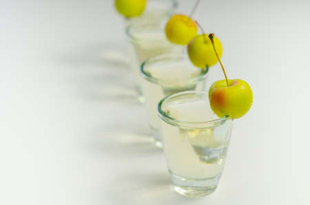 Delicious Calvados served in shot glasses decorated with crab apples, an alcoholic drink made of apples and pearsの写真素材