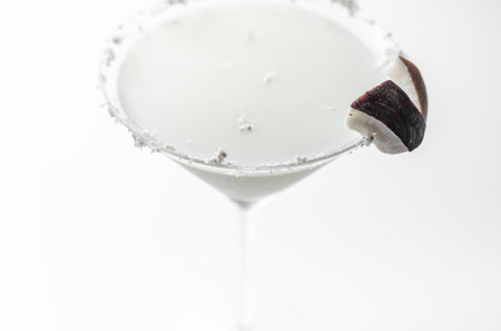 Coconut cocktail in martini glass based on the rum decorated with coconut flakes and coconut pieces, white drinkの写真素材