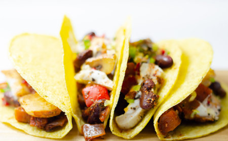 Mexican tacos shells with chicken and red kidney beans, onion,  red and green peppers, and salsa sauce, Latin foodの写真素材