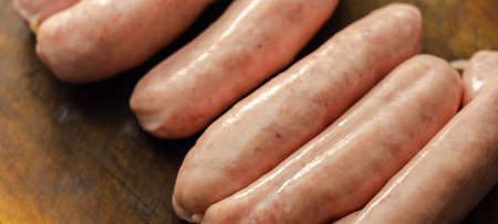 Raw classic British sausage made from prime cuts of pork on the wooden board, prime pork sausagesの写真素材