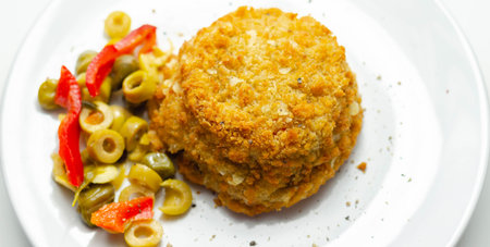 Cod and prawns red Thai style fish cake served with pickled olives, gherkin, garlic, and red...