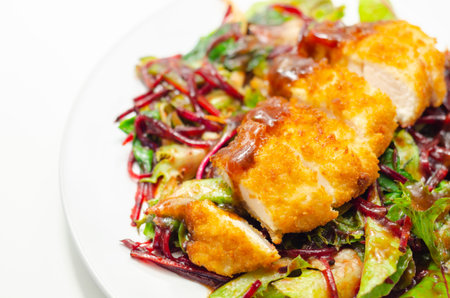 Breaded crispy chicken breast fillet with mixed salad and grated beetroot, tasty lunchの写真素材