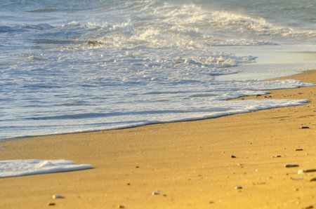 View on the seawater affecting the sand on the beach, sea waves flowing  calmly at the sand,...