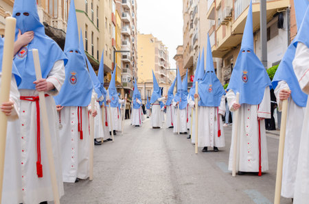 ALMERIA, SPAIN - APRIL 04, 2023 Procession of people in the holy week. Residents participating in the procession wear platforms with images of saintsのeditorial素材