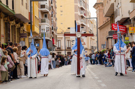ALMERIA, SPAIN - APRIL 04, 2023 Procession of people in the holy week. Residents participating in the procession wear platforms with images of saintsのeditorial素材