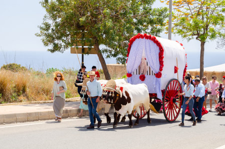 NERJA, SPAIN - 15 MAY 2022 City residents, carriages, carts, horses, oxen and tractors, as well as...