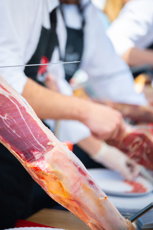 Ham cutting master, professional knife master, Cortador de jamon, man cutting jamon ham placed in a stand, gastronomyの写真素材