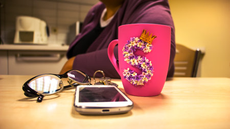 the hands of a beautiful woman holding a pink cup with the letter Sの写真素材