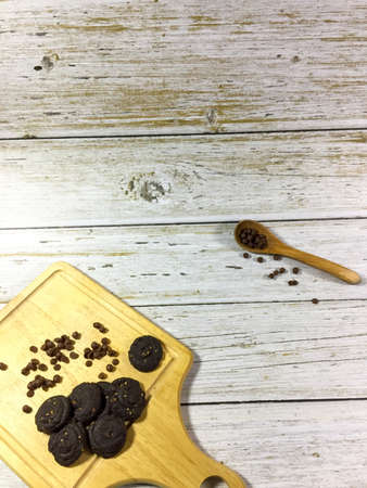 Mocha with chocolate chip cookies. Decorated with a chopping board and wood spoon with several perspectives. Selective focus. Had a little big nose some area.の写真素材