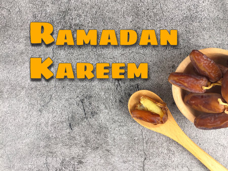 Position the dates in a tray container, and also a written Ramadan Kareem on the background.の写真素材