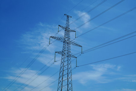 Electric pole and wires against the blue sky.