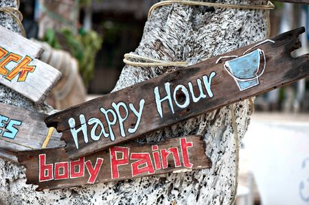 happy hour, body paint board notices on tree trunkの写真素材