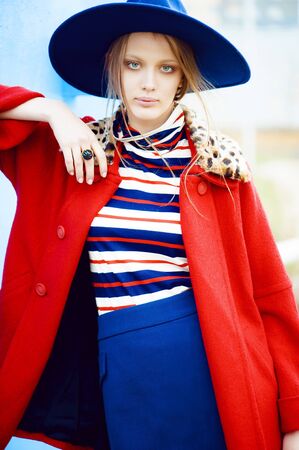 Fashion model in red coat and blue hatの写真素材