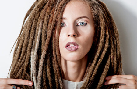 Beautiful girl with dreadlocks in white suit
