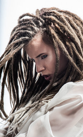 Beautiful girl with dreadlocks in white suit