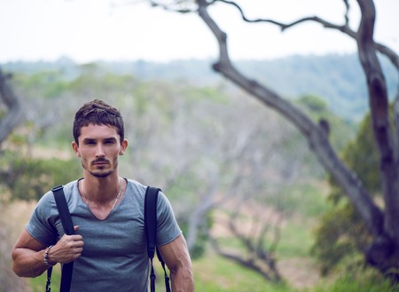 Handsome man walking in fieldの写真素材
