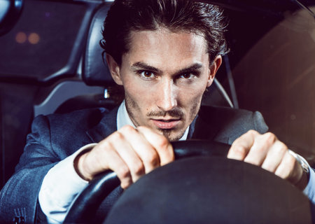 Man with beard in suit driving carの写真素材