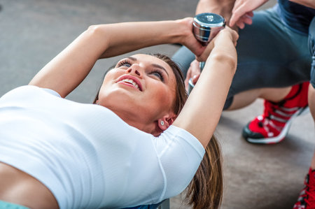 beautiful woman in gym with personal trainer