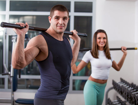 beautiful woman in gym with personal trainer