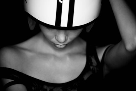 Portrait of beautiful young woman in shirt,white helmet pictured with star and stripes poses gesticulating arms on black background.Studio shot.Fashion look.Perfect clean skin.の写真素材